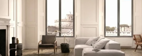 Soggiorno moderno e luminoso con nuovi infissi grigi dal profilo sottile e vista panoramica su Castel Sant'Angelo.