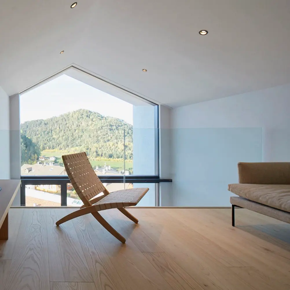 Parapetto Garda ONE in vetro trasparente installato su soppalco interno con pavimento in legno e vista su montagne.