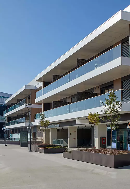Facciata di un edificio moderno con balconi multipli protetti da balaustre in vetro Garda ONE.
