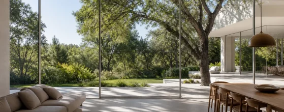 Interno luminoso con infissi minimali in alluminio a profilo sottile, giardino visibile