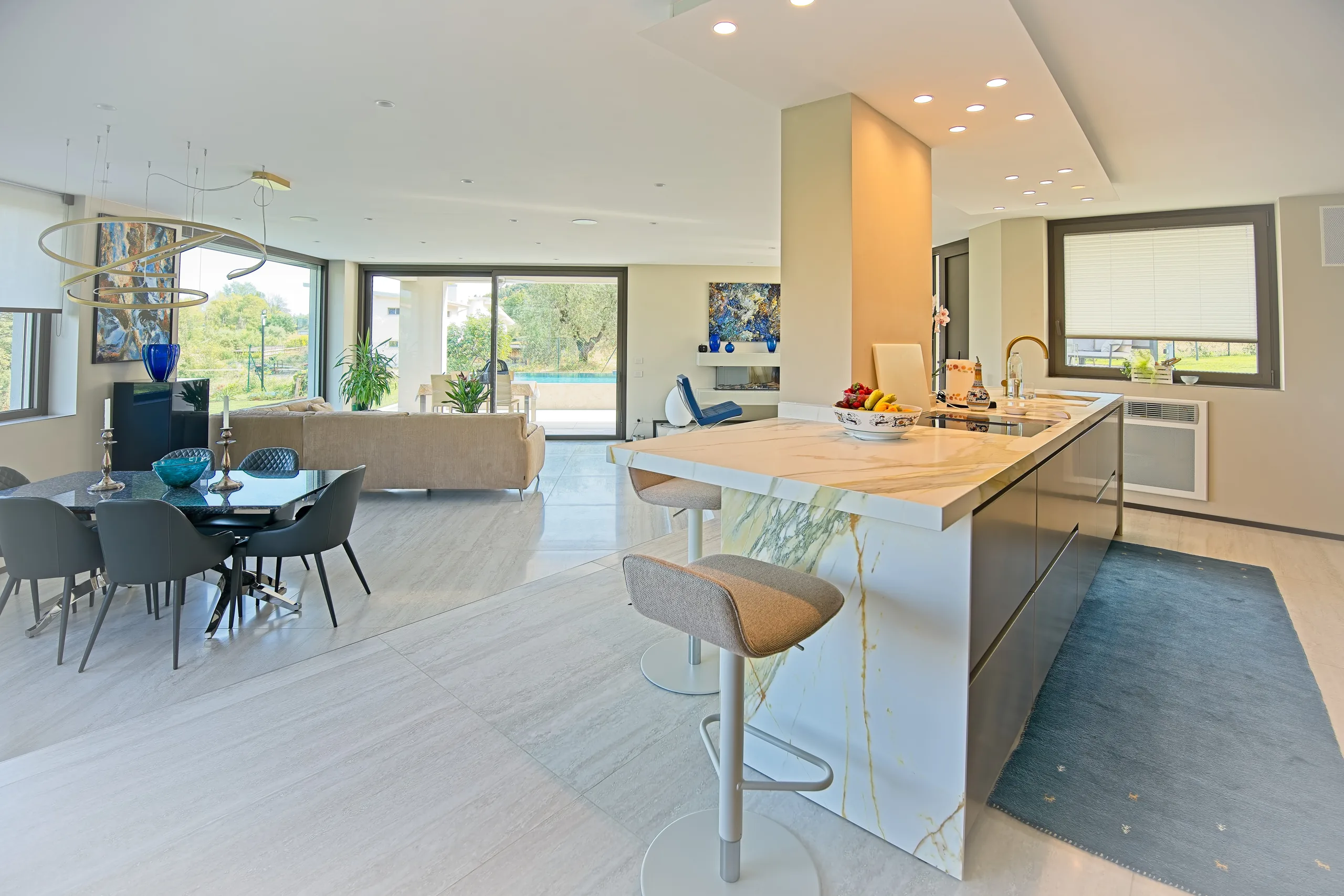 Open space con cucina e vetrate scorrevoli su piscina e giardino, villa a San Felice del Benaco